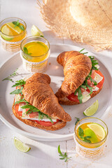 Tasty and fresh french croissant with prosciutto, camembert and arugula.