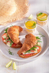 Fresh french croissant made of ham, cheese and vegetables.
