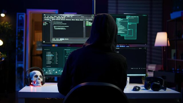 Hacker coding, developing zero day exploit undetectable by antivirus software installed on systems. Rogue programmer in apartment building script able to trick firewalls, camera B