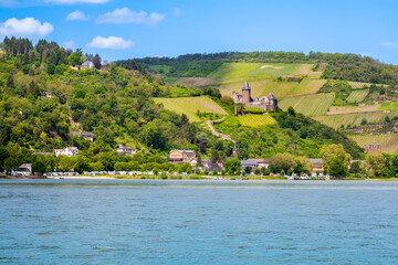 Bacharach am Rhein town with Stahleck castle and Wernerkapelle in Rhine Valley, Germany, seen from river. Rhine valley is famous tourist destination for romantic river cruise or vacation