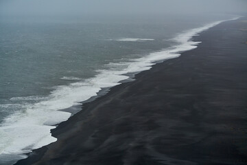 Aerial view of the black beach of Dyrhólaey in Iceland on a swell day