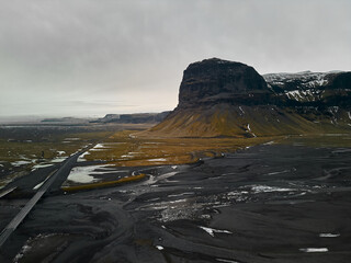 Aerial view of Volcanic Valley with river, snow-capped mountains bridge and road