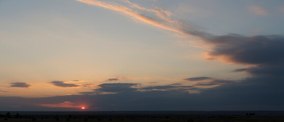 Landscape with bloody sunset. Panorama. Tragic gloomy sky. The last flashes of the sun on the storm clouds.