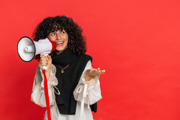 Caucasian young woman with curly hair talking with megaphone, proclaiming news, loudly announcing...