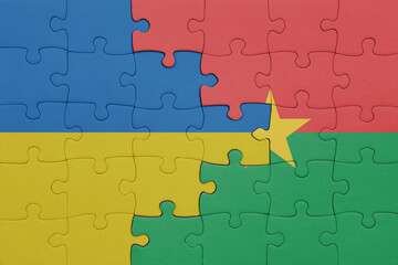 puzzle with the colourful national flag of burkina faso and flag of ukraine.