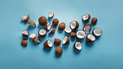 A bunch of coconut pieces are scattered across a blue background - Powered by Adobe
