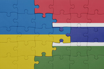 puzzle with the colourful national flag of gambia and flag of ukraine.