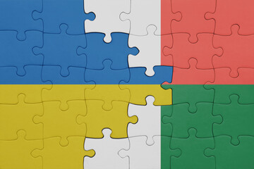 puzzle with the colourful national flag of madagascar and flag of ukraine.