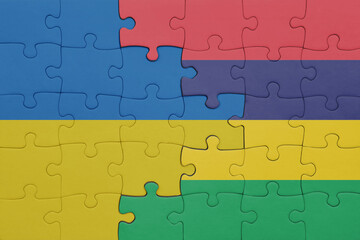 puzzle with the colourful national flag of mauritius and flag of ukraine.