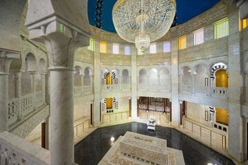 White marble walls, crystal chandelier and lattice windows under arches decorate family tomb of...