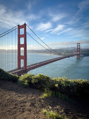 Scenic view of Golden Gate Bridge and cityscape of San Francisco, California, USA at sunrise against blue sky with clouds