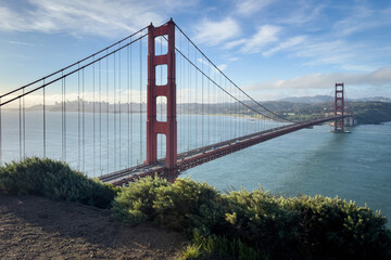 Scenic view of Golden Gate Bridge and cityscape of San Francisco, California, USA at sunrise against blue sky with clouds