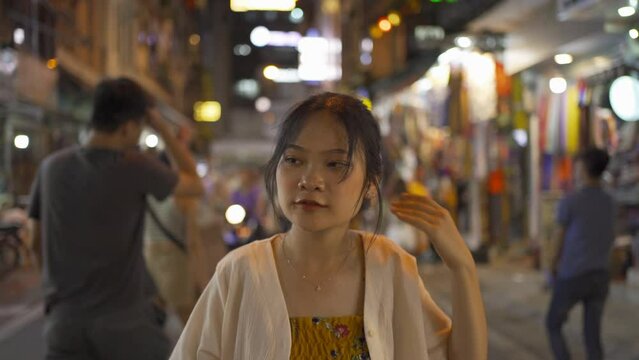 Drunk alcoholic woman Asian Vietnamese woman travel at night, drinking beer in market. People walking street fair in Hanoi city, Vietnam. Retail shops