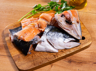 There are salmon trimmings on cutting board - head, spine, tail. Fish soup set is complemented with...
