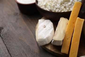 Dairy products. Different kinds of cheese on wooden table, closeup. Space for text