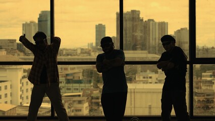Silhouette shot of skilled choreographer group dancing together with sky scrapper, cityscape...