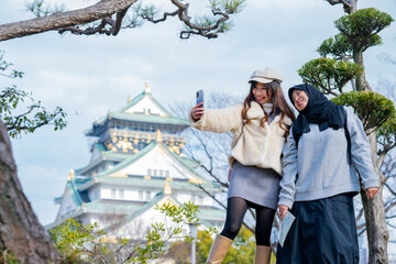 Travel, muslim travel, woman girl tourist Two Asian friends but different religions walking at...