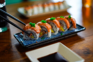 sushi roll topped wit salmon, Japanese traditional dishes, selective focus