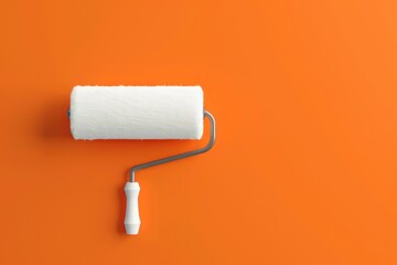 Obraz premium Paint roller on vibrant orange background with space for text or logo for business promotion or art projects