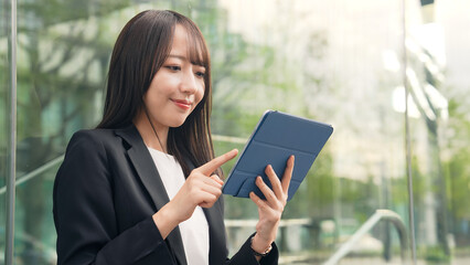街角でタブレットPCを使う女性ビジネスウーマン