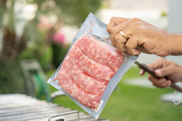Man opens a package of meat to make a barbecue