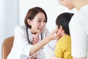 病院で子供の診察をする女性医師
