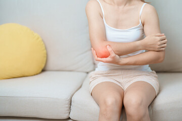 Woman having elbow ache at home, muscle pain due to lateral epicondylitis or tennis elbow. injury,...