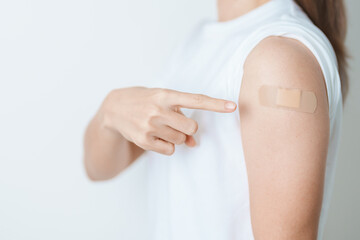 Woman with bandage after receiving vaccine. Vaccination and Immunization for Influenza, HPV,...