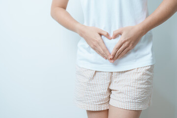 Woman hand heart shape over abdomen. Ovarian and Cervical cancer, Endometriosis, Hysterectomy,...