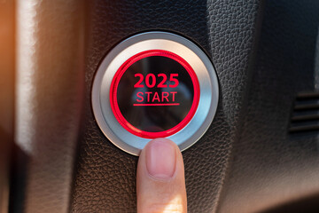 Finger press a car ignition button with 2025 START text inside  automobile. New Year New You,...