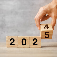 hand flipping block 2024 to 2025  text on table. Resolution, strategy, plan, goal, motivation, reboot, business and New Year holiday concepts
