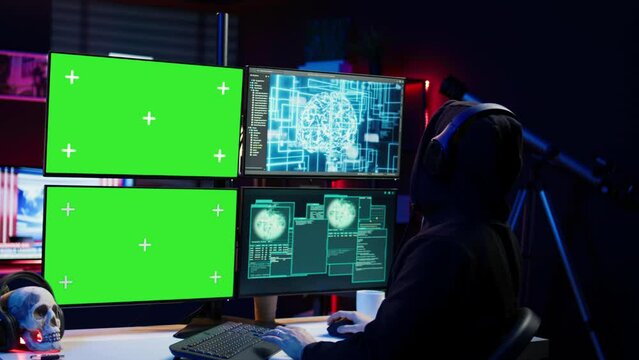 Cybercriminal using AI deep learning to produce virus corrupting data on mockup PC. Rogue developer working on isolated screen computer using artificial intelligence, penetrating security, camera B