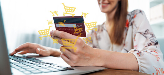 Elegant customer wearing floral shirt holding credit card typing laptop choosing online platform....