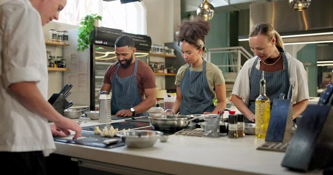 Cooking class, restaurant and people with chef instructor in kitchen for learning, education course or practice. Gastronomy, teaching and diverse students for meal, preparation or working on skills