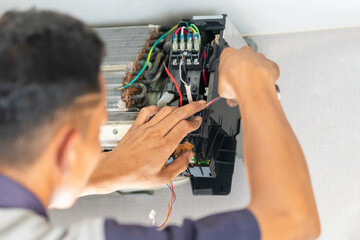 Technician checking air conditioning control board, Repairman fixed air conditioning systems,...