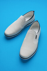 White Perforated Slip-On Shoes on Blue Background