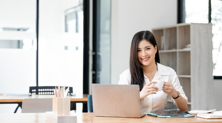 Asian Businesswoman Using laptop computer and working at office, doing planning analyzing the financial report, business plan investment, finance analysis concept.