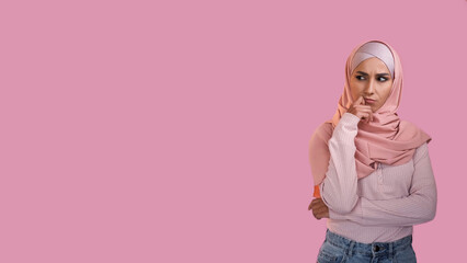 Pensive expression. Idea contemplation. Doubtful thoughtful woman in hijab thinking on problem isolated on pink empty space advertising background.