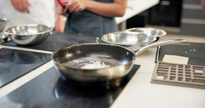 Hands, cooking class and pan in kitchen for learn, teacher and food for professional skills. Restaurant, fry or culinary student with oil for saute, onion or vegetables for prepare on hot stove top
