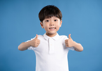 Portrait of asian boy posing on blue background