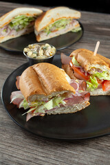 A view of plates of sandwiches, featuring a ham sandwich.