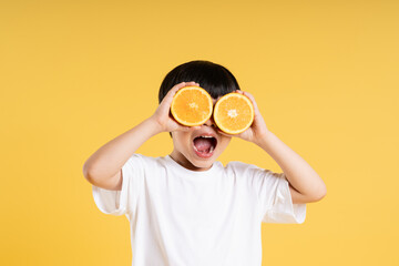 Portrait of adorable asian boy posing on yellow background