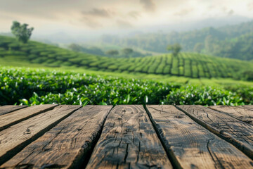 Naklejka premium A wooden desk top with blurred background of tea plantation. Good for background 