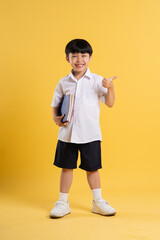 Portrait of adorable asian boy posing on yellow background