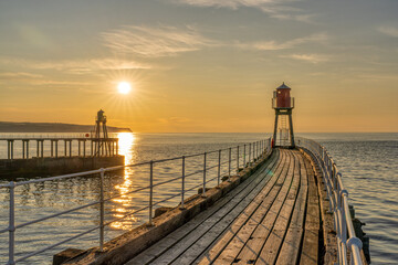 Sunset at the West and East Pier in Whitby, England, UK