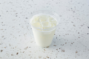 A view of a cold milk in a plastic cup.