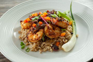 A view of a plate of brown stew shrimp.