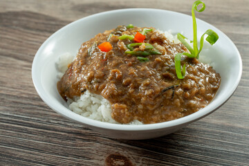 A view of a bowl of rice and gravy. 