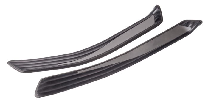 A black plastic decorative door sills in an automobile parsing for sale or repair in a workshop on a white isolated background in a photo studio.