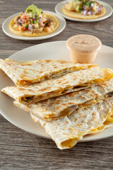 A view of some vegan Mexican entrees, featuring a quesadilla and some tacos.